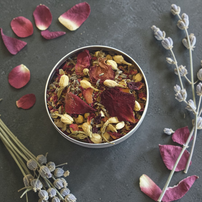 Zen Blend incense in a tin with rose petals and lavender on a dark surface